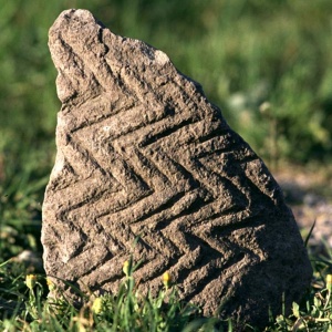 Frammento di bacino di trachite decorata con motivi geometrici